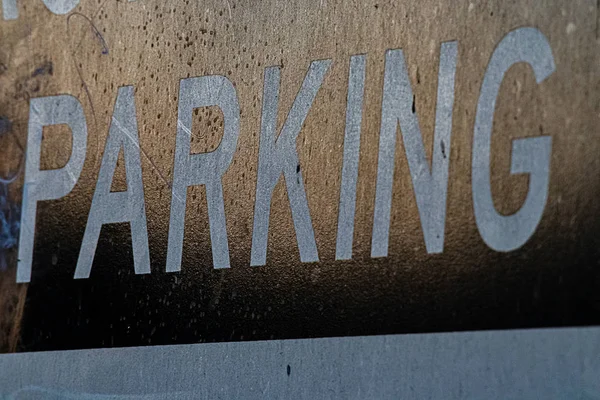 A metalic sign saying parking worn by time and weather — Stock Photo, Image