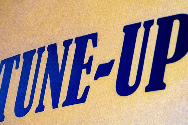 sign advertising tune up in bold bright blue letters