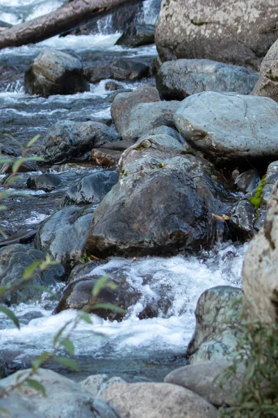 Grandes rochas saindo das corredeiras azuis do rio — Fotografia de Stock