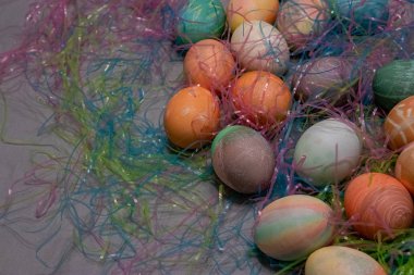 Renkli Paskalya yumurtaları Paskalya otlarıyla dolu bir masada toplandı.