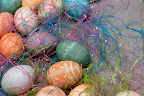 Oeufs de Pâques colorés teints rassemblés sur une table avec de l'herbe de Pâques — Photo