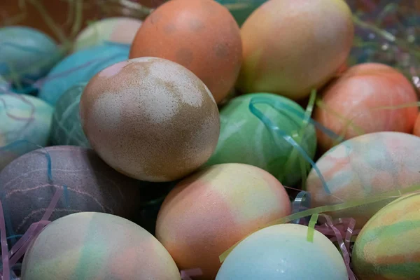 Kleurrijke geverfde paaseieren verzameld op een tafel met Pasen gras — Stockfoto