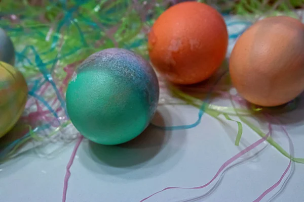 Colorful dyed easter eggs gathered on a table with easter grass — Stockfoto