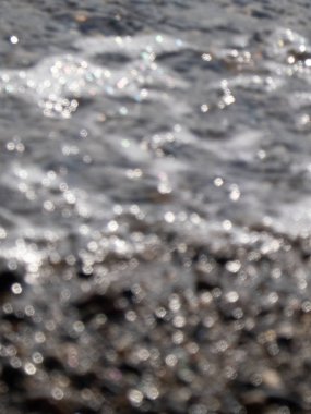 Kayalık kıyı şeridi, taşların üzerinde gelgitler var.