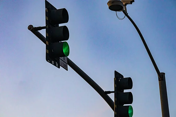 Semáforo de rua pendurado no pólo de apoio vermelho brilhante — Fotografia de Stock
