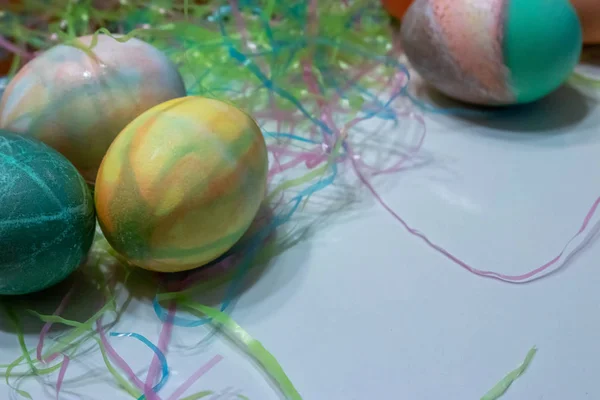 Kolorowe wielkanocne jaja zebrane na stole z trawą wielkanocną — Zdjęcie stockowe