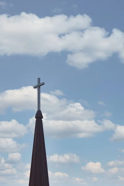 Cruzar en la parte superior del campanario de la iglesia contra el cielo nublado en el fondo — Foto de Stock