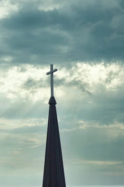 Cross up on the top of church steeple against cloudy sky in background — Stock Photo, Image