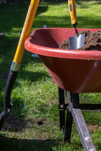 Wheelbarrow filled with dirt and a trowle — Stock Photo, Image