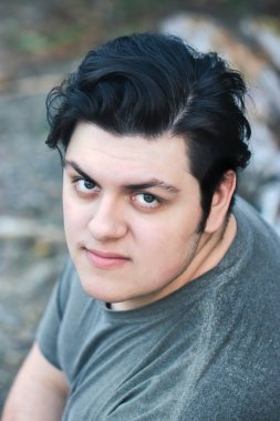 20 'li yaşlarda kendine güveni tam genç bir adam etrafa bakıyor.