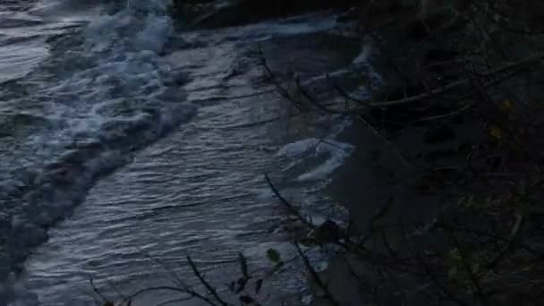 Kleine golven op rotsachtige kust in de avond — Stockvideo