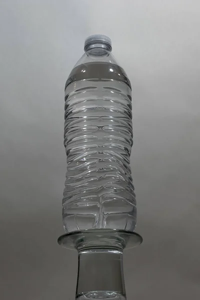 Plastic water bottle with light and shadows against white — Stock Photo, Image