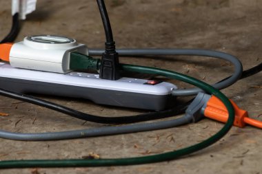 Çoklu prizleri ve prizleri olan adaptör dışarıda oturuyor