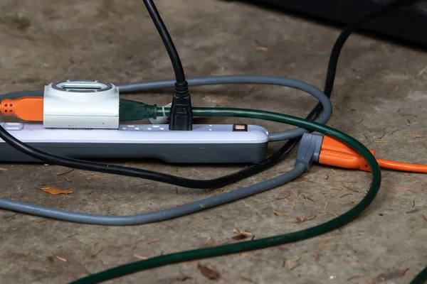 Adapter with multiple outlets and plugs sitting outside — Stock Photo, Image