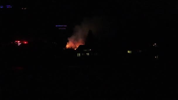 Ein Haus in Flammen mit Einsatzfahrzeugen in der Nähe — Stockvideo