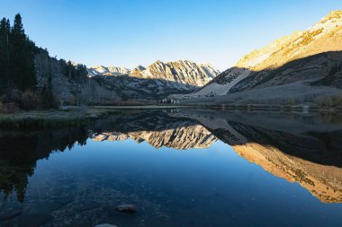 parlak mavi hala göl yüzeyi çevresindeki dağı yansıtıyor.