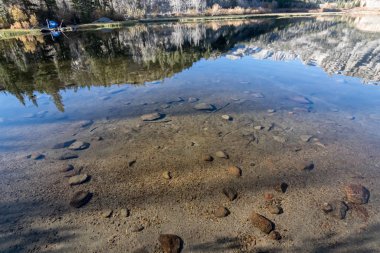 Göl yatağı yansımaları ve gölgelerle dolu bir su yatağı.