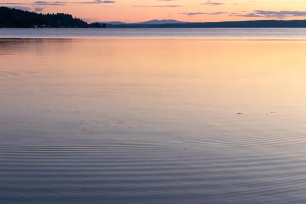 Спокойная чистая вода пюре звук с красочным закатом — стоковое фото