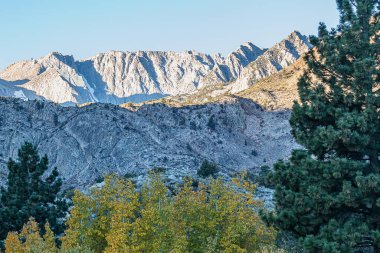 Dağlık tepeler ve vadiler sabah güneşiyle parıldıyor.