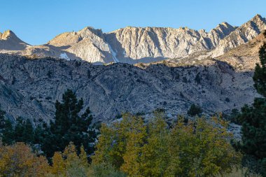 Dağlık tepeler ve vadiler sabah güneşiyle parıldıyor.