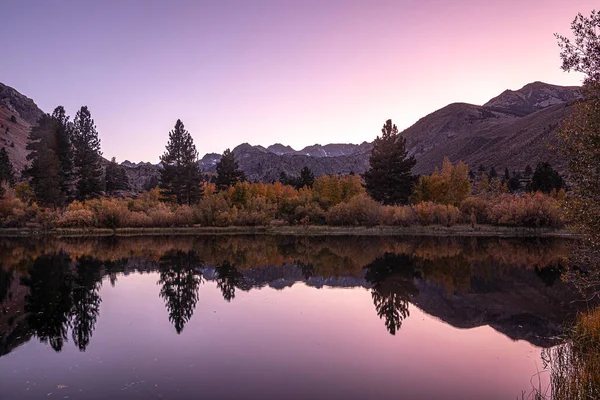 鏡のような湖の景色の上で穏やかな夜のピンクウォッシュ ロイヤリティフリーのストック画像
