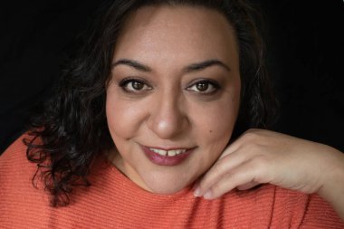 Uzun saçlı, esmer, etnik bir kadın.