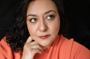 Uzun saçlı, esmer, etnik bir kadın.