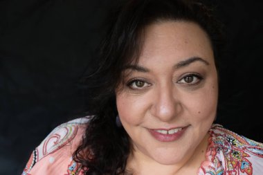 Uzun saçlı, esmer, etnik bir kadın.