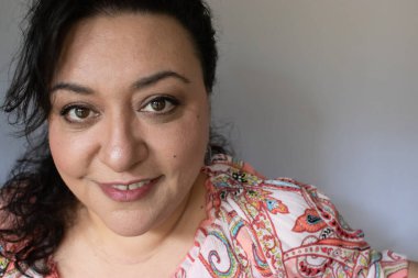 Uzun saçlı, esmer, etnik bir kadın.