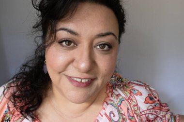 Uzun saçlı, esmer, etnik bir kadın.