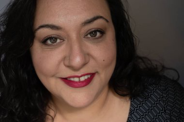 Uzun saçlı, esmer, etnik bir kadın.