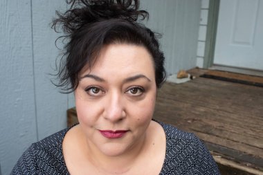 Uzun saçlı, esmer, etnik bir kadın.