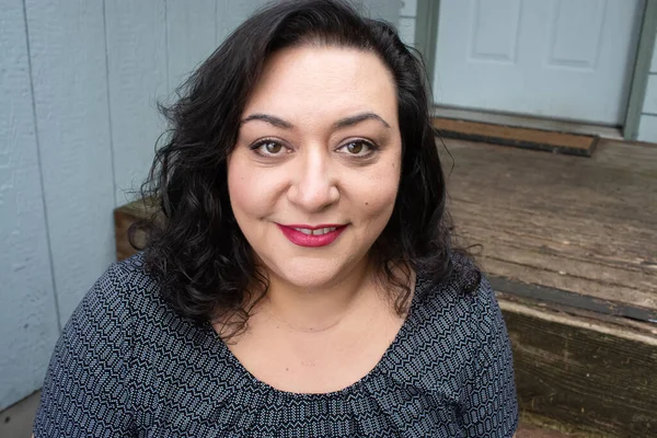 Uzun saçlı, esmer, etnik bir kadın.