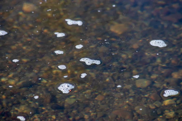 small white bubbles on a river surface