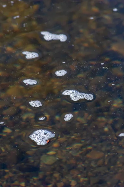 the white bubbles on a shallow river