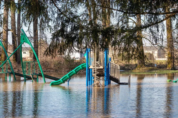 En översvämmad allmän park med lekplats — Stockfoto