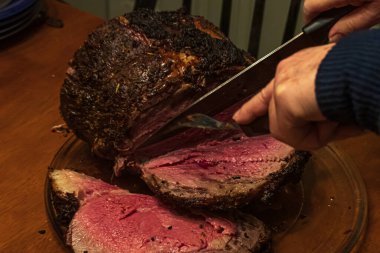 Az pişmiş koyun rostosu masada servis ediliyor.