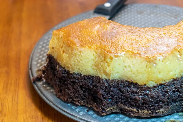 Un gâteau au chocolat et à la crème anglaise avec des tranches de celui-ci — Photo