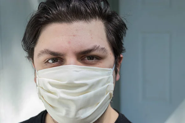 young man with dark hair in face mask for protection