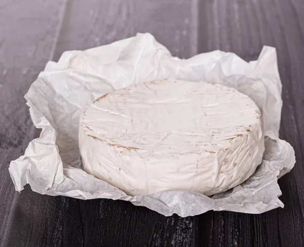 Queijo Brie Papel Branco Uma Mesa Madeira — Fotografia de Stock
