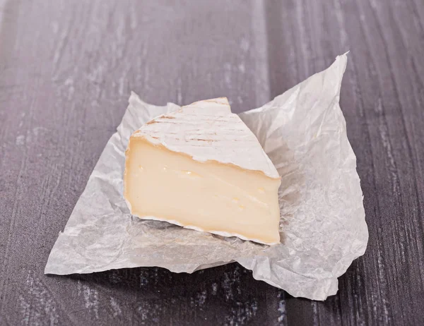 Sýr Bílém Papíru Dřevěném Stole — Stock fotografie