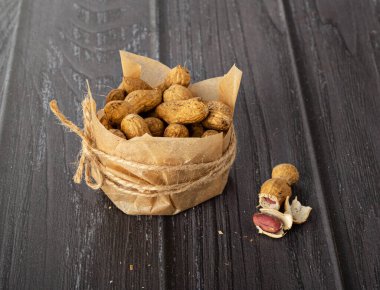 Karanlık bir arka planda el işi kağıdındaki fıstıklar.