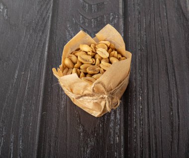 Karanlık bir arka planda el işi kağıdındaki fıstıklar.