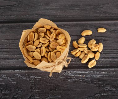 Karanlık bir arka planda el işi kağıdındaki fıstıklar.