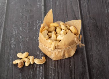 Karanlık bir arka planda el işi kağıdındaki fıstıklar.