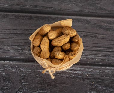 Karanlık bir arka planda el işi kağıdındaki fıstıklar.