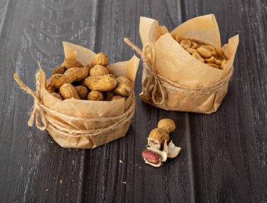 Karanlık bir arka planda el işi kağıdındaki fıstıklar.