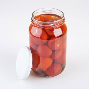 Beyaz arka planda izole edilmiş bir kavanoz turşulu ve tuzlu domates.