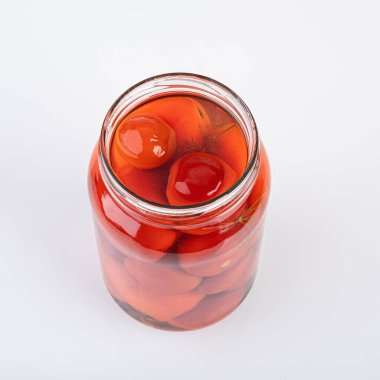 Beyaz arka planda izole edilmiş bir kavanoz turşulu ve tuzlu domates.