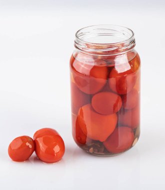 Beyaz arka planda izole edilmiş bir kavanoz turşulu ve tuzlu domates.